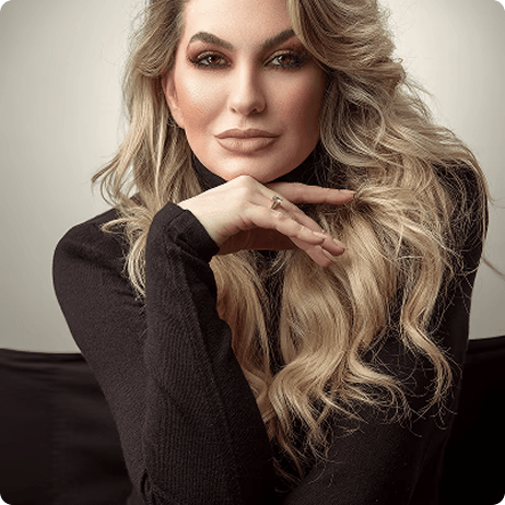 Mulher numa foto de perfil, usando roupa social e expressando postura confiante.